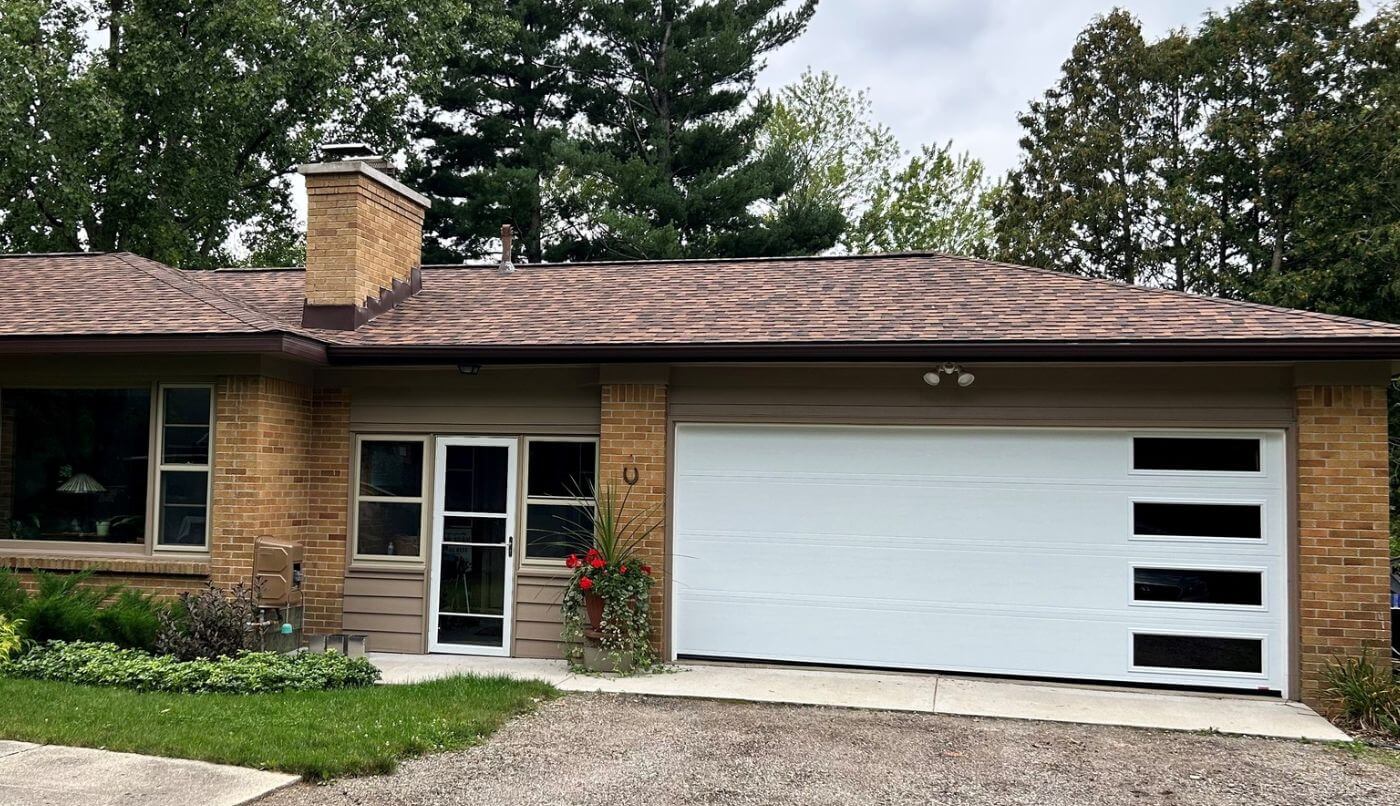 A garage with a white door and a brown roof, exemplifying a simple yet elegant design in a residential setting.