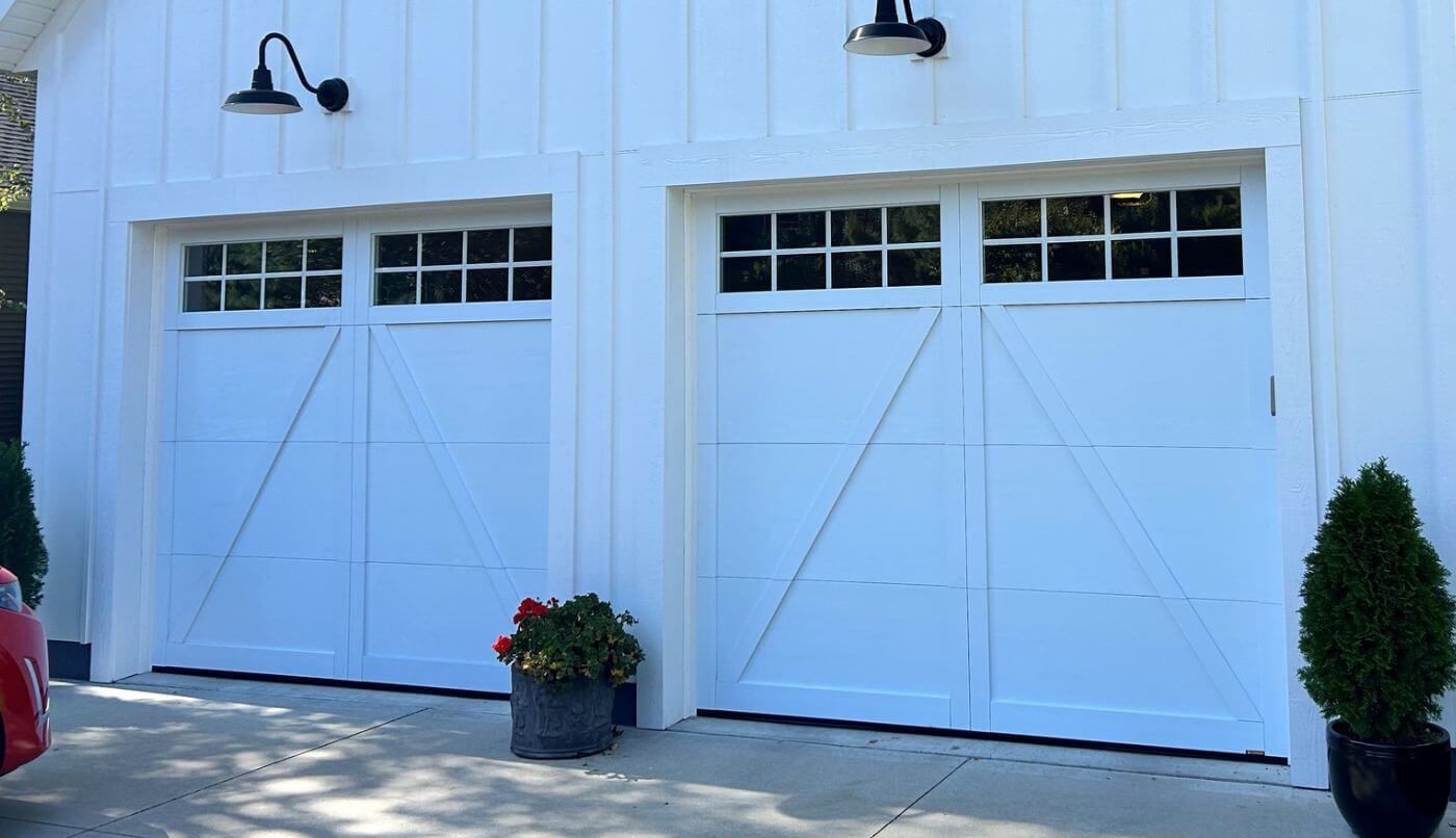 Two garage doors with lights positioned on either side, highlighting the architectural features.