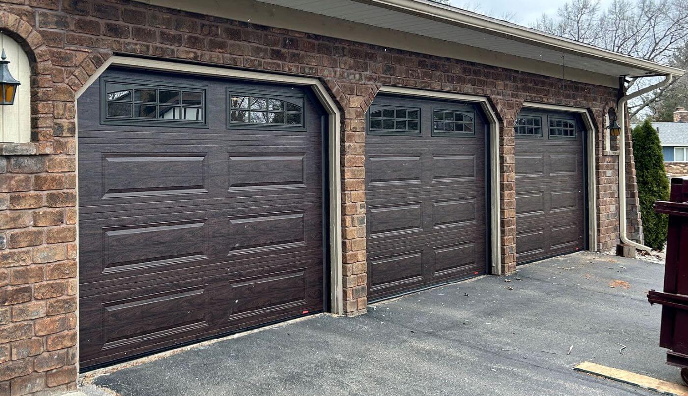 A trio of garage doors with windows, highlighting a stylish architectural detail.