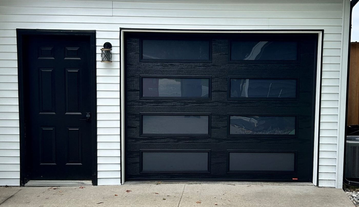 A modern black garage door with a black door adjacent, highlighting a stylish design combination.